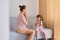 Portrait of hard working female speech therapist having lesson with little girl, people wearing casual style clothing, sitting on