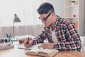 Portrait of hardworking student with book preparing for test in university