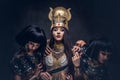 Portrait of haughty Egyptian queen in an ancient pharaoh costume with two concubines. Royalty Free Stock Photo