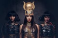 Portrait of haughty Egyptian queen in an ancient pharaoh costume with two concubines. Royalty Free Stock Photo