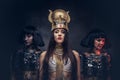 Portrait of haughty Egyptian queen in an ancient pharaoh costume with two concubines. Royalty Free Stock Photo