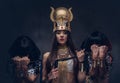 Portrait of haughty Egyptian queen in an ancient pharaoh costume with two concubines. Royalty Free Stock Photo