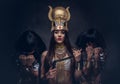 Portrait of haughty Egyptian queen in an ancient pharaoh costume with two concubines. Royalty Free Stock Photo