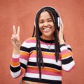 Portrait, headphones and black woman with peace sign isolated on orange wall for gen z music or mental health. Young