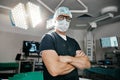 Portrait, healthcare and arms crossed by man doctor in operating room with confidence in medical, surgery or emergency Royalty Free Stock Photo