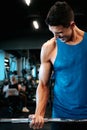 Portrait of healthy fitness man working out at gym. Athlete and professional certified trainer training with weights at gym