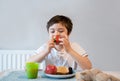 Portrait Healthy kid eating strawberries, apple and toast bread. Hungry little boy having breasfast at home., Child tasting fresh Royalty Free Stock Photo