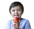 Portrait of healthy kid holding organic red apple on his hand and looking at camera with smiling face, Isolated  child boy eating Royalty Free Stock Photo