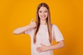 Portrait of healthy satisfied pleased lady hand tummy raise thumb up approve food quality on yellow background Royalty Free Stock Photo