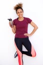 Healthy sporty young african american woman with water bottle against white background