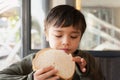 Portrait healthy young boy eating bacon sandwich, School Kid having breakfast in the cafe be for go to school, Child bitting toast