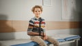 Portrait of a Healthy Young Handsome Teenage Boy Sitting on a Bench with His Hand in an Arm Brace in Royalty Free Stock Photo