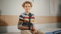 Portrait of a Healthy Young Handsome Teenage Boy Sitting on a Bench with His Hand in an Arm Brace in Royalty Free Stock Photo