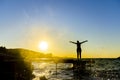 Portrait of healthy young hispanic woman standing on the beach pier with her hands outstretched against sunset Royalty Free Stock Photo