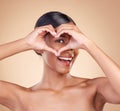 Portrait, heart and hand gesture with a woman in studio on a beige background for beauty or skincare. Face, hands and