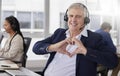 Portrait, heart hands or mature happy man in call center with smile excited about customer care services in office