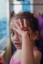 Portrait of Henna ornaments on little girl`s hand covering face Royalty Free Stock Photo