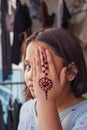 Portrait of Henna ornaments on young girl`s hand covering face Royalty Free Stock Photo