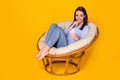 Portrait of her she attractive pretty focused cheerful cheery girl sitting in comfy wicker chair using device gadget