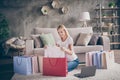 Portrait of her she nice attractive cheerful fashionable careful mature lady sitting on carpet looking buying new things