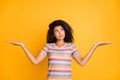 Portrait of her she nice attractive doubtful wavy-haired girl in striped tshirt holding on palms invisible objects Royalty Free Stock Photo