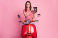 Portrait of her she nice attractive lovely cheerful girl riding sitting on moped holding in hands using pos terminal