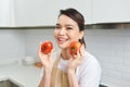 Portrait of her she nice attractive lovely confident cheerful cheery girl holding in hands tomato cooking everyday domestic meal