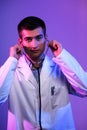 Portrait of a hero in a white coat. Cheerful smiling young doctor with stethoscope in medical hospital standing on blue Royalty Free Stock Photo