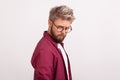 Portrait of hesitant bearded man in checkered shirt wearing eyeglasses and seriously looking at Royalty Free Stock Photo