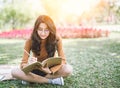 Portrait of high school girl lay down and read a book in park, education reading book and writing concept Royalty Free Stock Photo