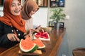 Portrait hijab young woman slice watermelon