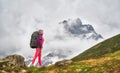 Portrait of hiker with a backpack at the beautiful mountains background.