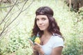 Portrait of hippie girl in forest with flowers