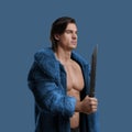 Fashionable guy with knife dressed in blue fur coat Royalty Free Stock Photo