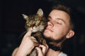 Portrait of hipster man hugging his cute cat with amazing green Royalty Free Stock Photo