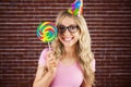 Portrait of a hipster with a party hat holding a lollipop Royalty Free Stock Photo
