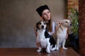 Portrait of a hipster tattoed girl with her little dogs in room with loft interior. Royalty Free Stock Photo