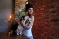 Portrait of a hipster tattoed girl with her little dogs in room with loft interior. Royalty Free Stock Photo