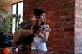 Portrait of a hipster tattoed girl with her little dogs in room with loft interior. Royalty Free Stock Photo