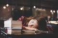 Portrait of hipster teenage sleeping on table at cafe looks tire