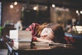 Portrait of hipster teenage sleeping on table at cafe looks tire