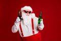 Portrait of his he attractive cheerful funny fat white-haired Santa holding in hand beer bottles dancing chill having