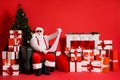 Portrait of his he attractive funky fat amazed stunned Santa sitting in armchair living-room reading long paper letter