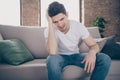 Portrait of his he nice attractive miserable depressed guy sitting on divan feeling bad head ache after party at modern Royalty Free Stock Photo