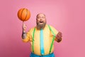Portrait of his he nice cheerful cheery bearded guy spinning orange ball on finger having fun isolated over pink pastel