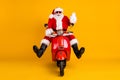 Portrait of his he nice funny comic childish cheerful cheery Santa riding motor bike traveling having fun waving hello