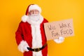 Portrait of his he nice serious fired white-haired Santa holding in hands paper card promo will work for food industry