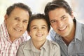 Portrait Of Hispanic Grandfather, Adult Father And Son Relaxing At Home