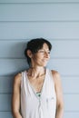 Portrait of hispanic woman with summer dress and ponytail while leaning on wood wall Royalty Free Stock Photo