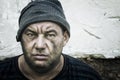 Portrait of a homeless man in a knitted hat. Look at the camera Royalty Free Stock Photo